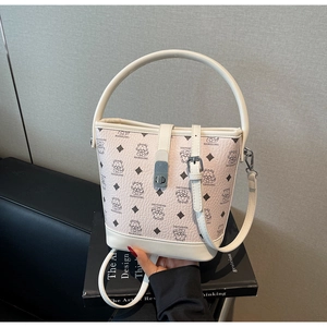 Close-up of cream leather bucket bag with printed cat patterns and metallic clasp detail