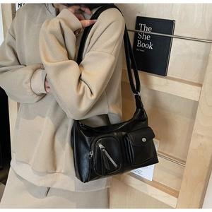 Detail view of black PU leather hobo bag with zip pocket and metallic snap button