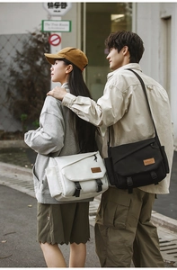 Detail of crossbody messenger bags with buckle closures in black and beige canvas