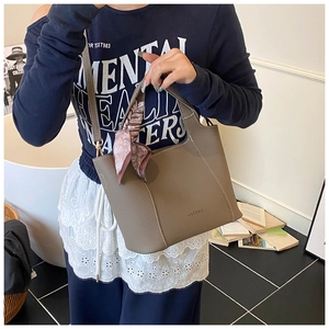 Detail of lychee pattern leather tote bag with heart silk scarf and contrast stitching