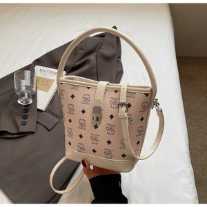 Close-up of the pebbled leather texture and bear print on this beige bucket bag