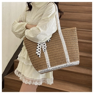 Détail d'un sac cabas en paille avec paillettes argentées et un foulard à pois noir et blanc