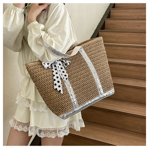 Détail du sac cabas en paille tissé avec paillettes argentées et nœud à pois noir et blanc