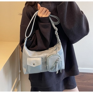 Detailed macro view of the multi-pocket shoulder bag in light blue-grey textured PU leather