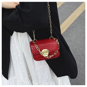 Detail of red crocodile texture girl shoulder bag with gold heart lock and chain strap