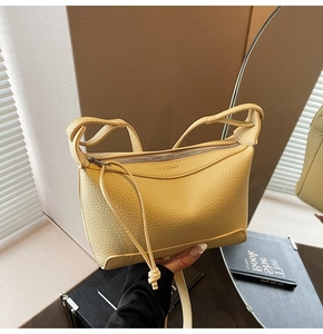 Detail of light yellow lychee pattern leather shoulder bag with metallic zipper and CLEA-K logo