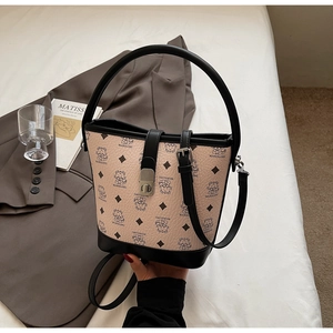 Detailed view of beige litchi grain bucket bag with cartoon bear motifs and black straps