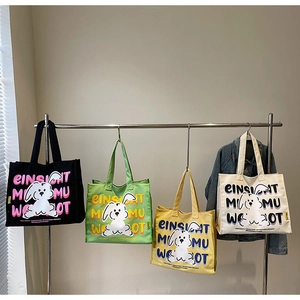 Row of colorful canvas tote bags with cartoon rabbit prints and long handles hanging on wall