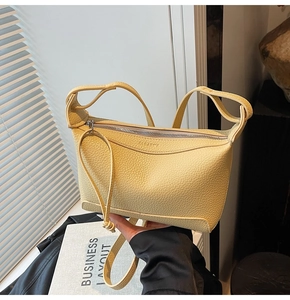 Detail of yellow lychee grain leather shoulder bag with silver zipper and slim strap