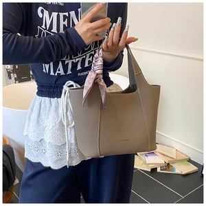Detailed texture of taupe leather tote with white stitching and pink silk scarf handle