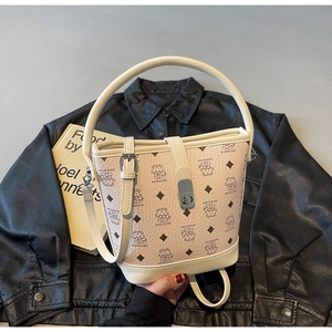 Detail of cream bucket bag featuring cute bear prints and metallic buckle closure