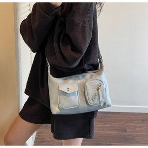 Close-up of light blue hobo bag showing multi-pocket design and faux leather texture