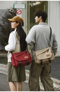 Detail of red and khaki utility messenger bags with buckles and side pockets