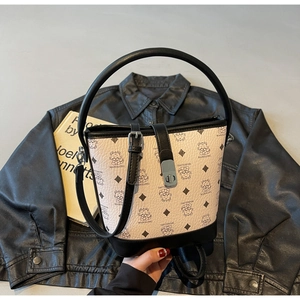 Detailed close-up of cream bucket bag featuring bear print and black leather accents