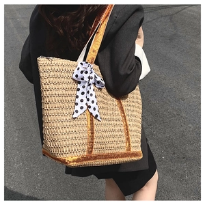 Détail du sac en paille avec bandoulière pailletée dorée et nœud à pois décoratif