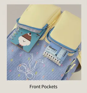 Detail of color-block backpack showing dual yellow front pockets and bow embroidery