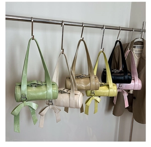 Detailed view of colorful Boston pillow bags with large bow charms and belt buckle accents