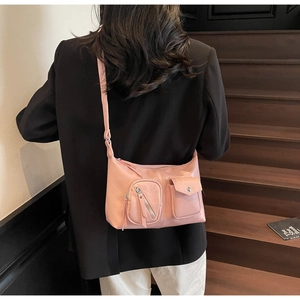 Pink crossbody bag with pleated texture and multi-pocket design shown on model