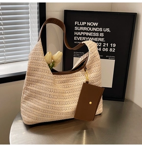 Close-up of woven straw tote bag with brown leather handles and matching card holder