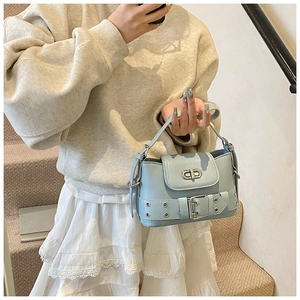 Détail du sac seau bleu clair avec boucle décorative et fermoir rotatif métallique