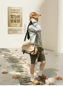 Khaki canvas messenger bag with double buckles and adjustable strap in outdoor street style