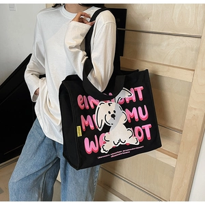 Detail of a black canvas tote bag featuring a cartoon rabbit and graffiti print
