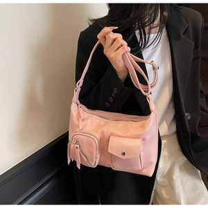 Close-up of pink faux leather crossbody bag with dual functional pockets and silver hardware