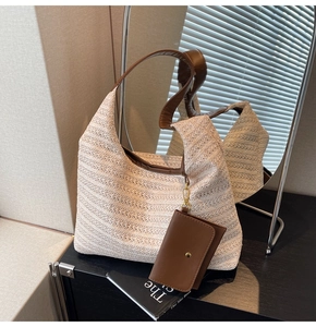 Detailed straw woven tote bag with brown leather straps and a matching mini flap pouch charm