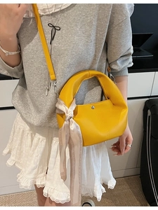 Gelbe Hobo-Tasche aus Leder mit Seidentuch, getragen als Umhängetasche am Model