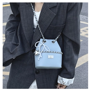 Light blue bucket bag with silver clasp, pearl bow charm and chain strap detail