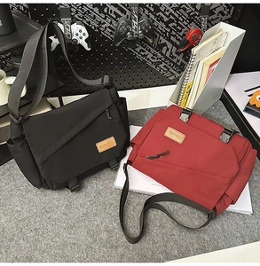 Detail of durable nylon messenger bags in black and red with adjustable wide straps