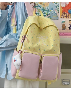 Detail of yellow plaid backpack with pink pockets and cute cloud plush keychain accessory