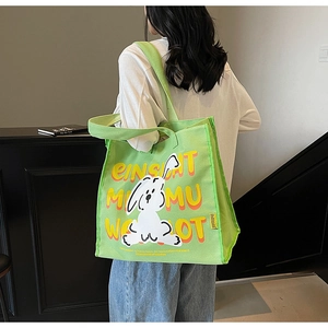 Detail view of light green canvas tote bag with cartoon rabbit and artistic letters