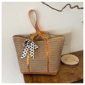 Détail du sac cabas en paille avec bandoulière à paillettes, nœud à pois et fermeture éclair