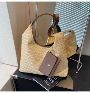 Straw hobo bag with brown leather strap and mini coin purse detail shown in mirror