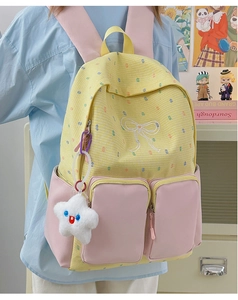 Detail of color-block school backpack with yellow plaid patterns and pink side pockets