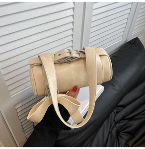 Detail of beige cylindrical Boston bag with matte leather and adjustable wide strap