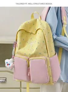 Detail of yellow checkered backpack with pink zipper pockets and white bow embroidery