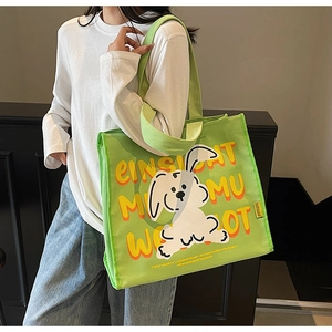Detailed side view of grass green canvas tote bag featuring a cute white rabbit cartoon print