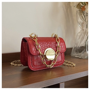 Detail of red croc-effect handbag with gold heart lock and chunky metal chain