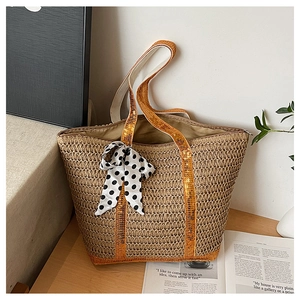 Détail du sac cabas en paille avec paillettes dorées, nœud à pois et fermeture éclair