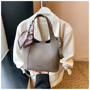 Macro detail of elephant grey pebble leather handbag with patterned silk scarf handle wrap