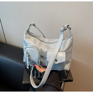 Detail of light blue-grey leather shoulder bag with functional multi-pocket design