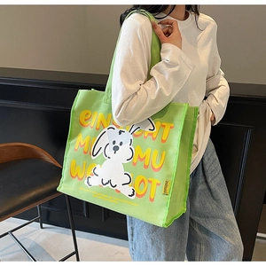 Detailed close-up of a large green canvas tote bag with a cute white bunny and bold lettering