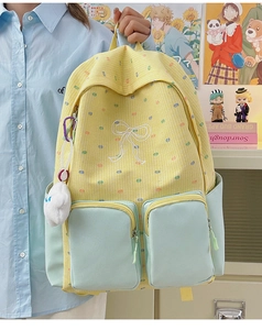 Detail of color-block backpack with checkered pattern, bow embroidery and plush charm