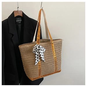 Détail du sac en paille avec paillettes orange et nœud papillon à pois noir et blanc