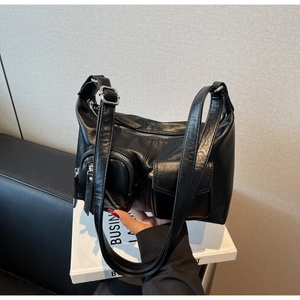 Detail of a vintage black hobo bag with front zip pockets and adjustable strap