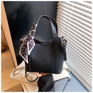 Detail of black lychee grain leather bucket bag with logo and heart print scarf