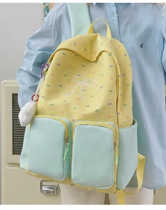 Detail of color-block backpack showing mint green pockets and yellow checkered fabric