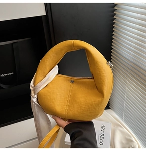 Détail du sac cabas jaune texture litchi avec foulard en soie et fermoir en métal brillant